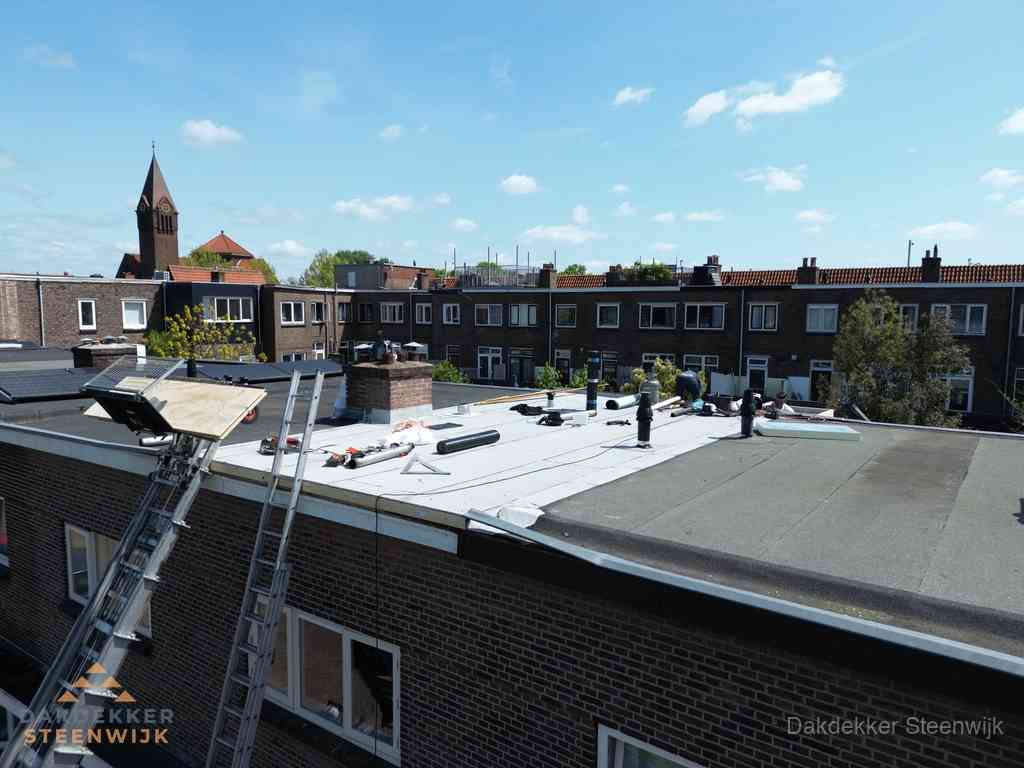 Dakdekkers aan het werk op plat dak in Steenwijk